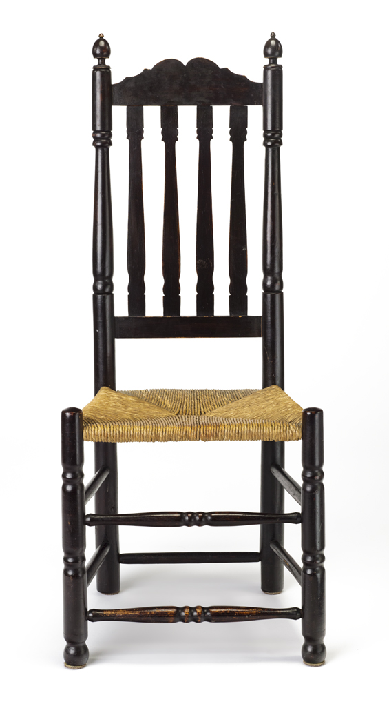 A banister side chair with woven fiber (rush) seat and varnished wood construction. A dark brown finish is present on the wooden surface.