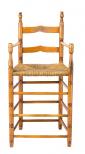 A child's high chair of turned wood legs, round spindles, two back rails and rush seat