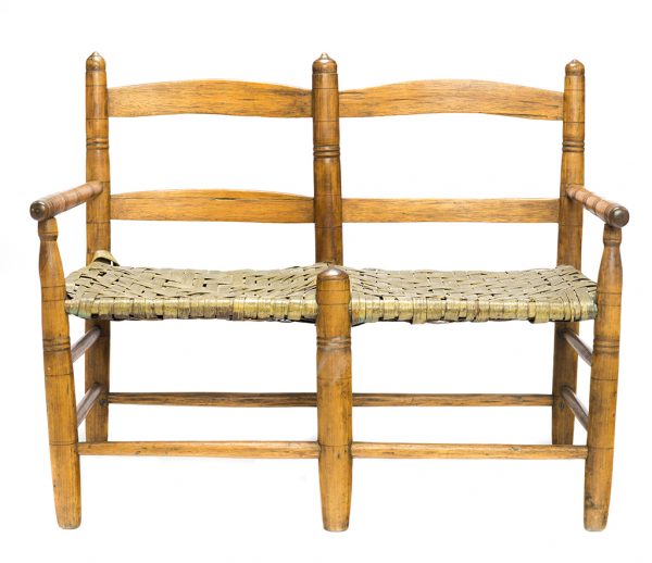 A wagon seat for two, of turned wood, split wood seats. The seat has a light green finish