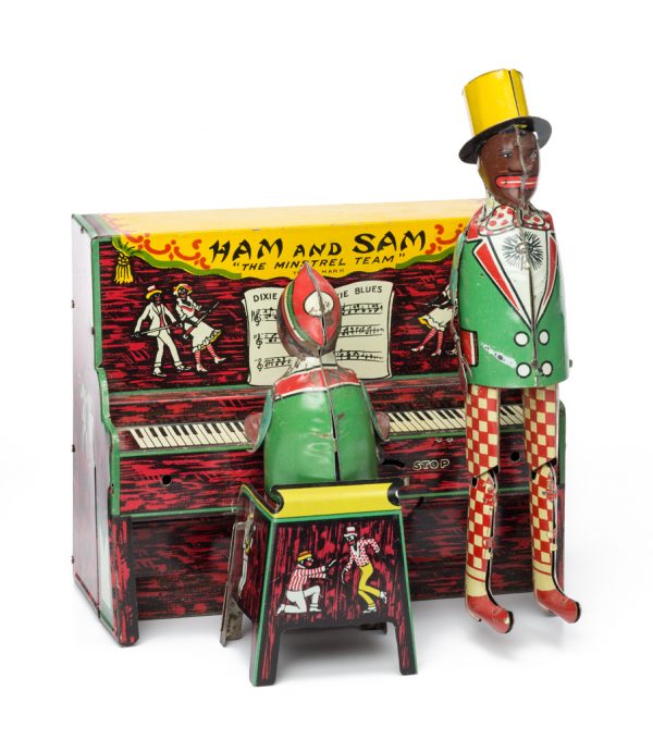 A windup toy featuring two performers. One figure sits at the piano, and the other stands adjacent ready to dance. 