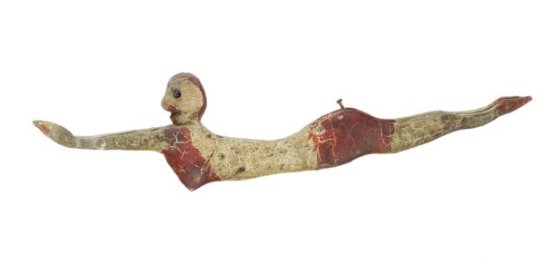 Profile of a female figure with outstretched arms in a dive, in light gray, dark gray and red paint for the swim cap, bikini, and diving shoes.