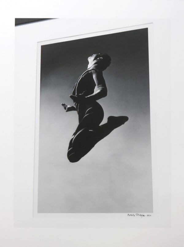 As seen from below, a woman jumps in the air, elbows and knees bent.