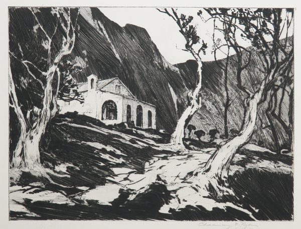 A small chapel with winding trees framing it and mountains in the background.
