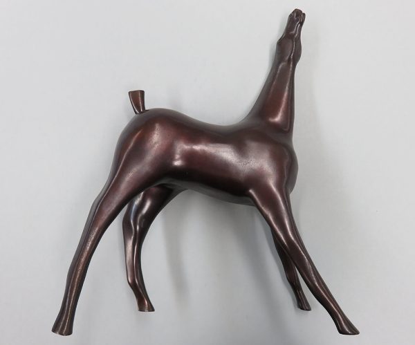 A sculpture of a slightly abstracted horse. The legs are spread and elongated. The horses nose is pointed to the sky and its mouth is open. The tail is upright and is cut short with a blunt end.