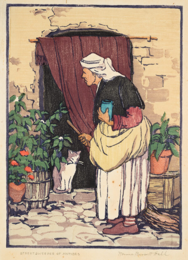 An older woman with a broom looks at a cat that stands in a doorway.