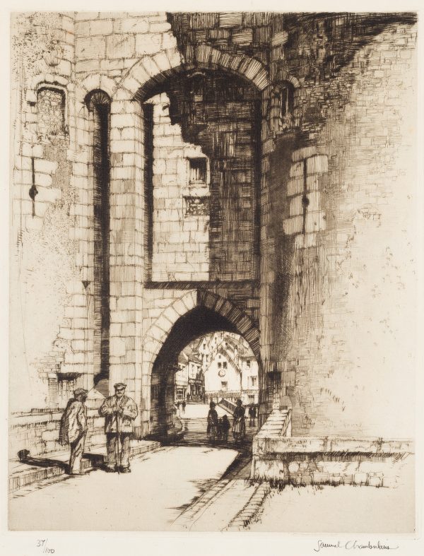 Two male figures stand in front of the arched doorway of a large stone building.