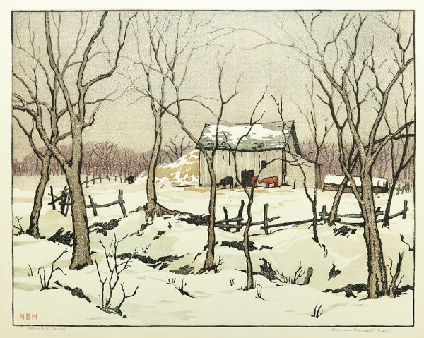 Cows are near a barn with trees and a fence in front. Snow coveres the ground and the roofs.