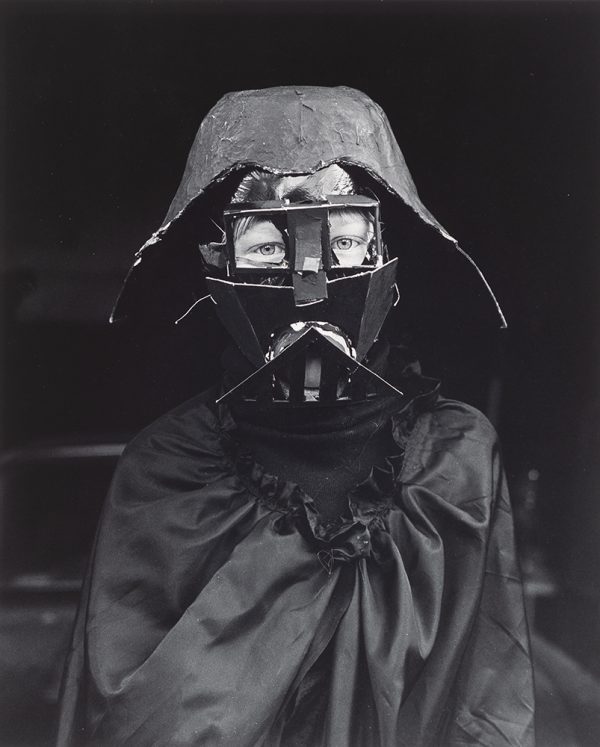 Young boy (Sage Schwarm) dressed up in homemade Darth Vader costume looking at viewers.