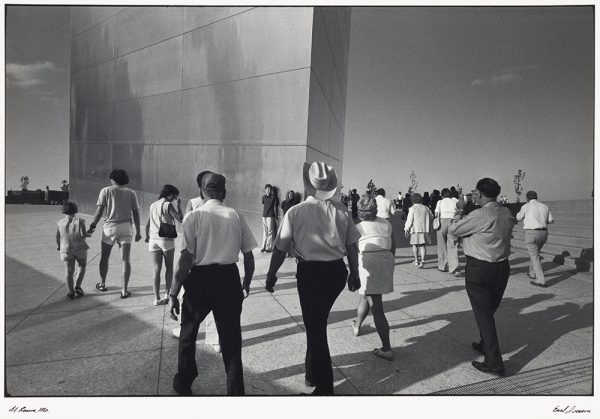 Many people walking and posing at close view of St. Louis Arch