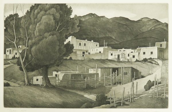 An adobe village with trees at the left. One is in full leaf and the other is leafless. A road runs from the bottom center toward the right center. There is a post fence along this road and a corral at center. Dark mountains are in the background.