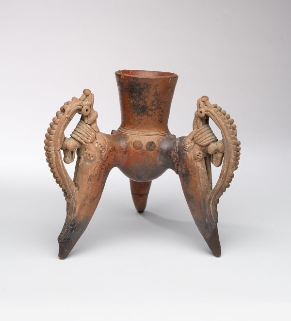 High tripod jar with each leg decorated with a mythical two headed animals (one is a armadillo), each with a decorative crest. The center is a rounded bottom vessel with tall neck.