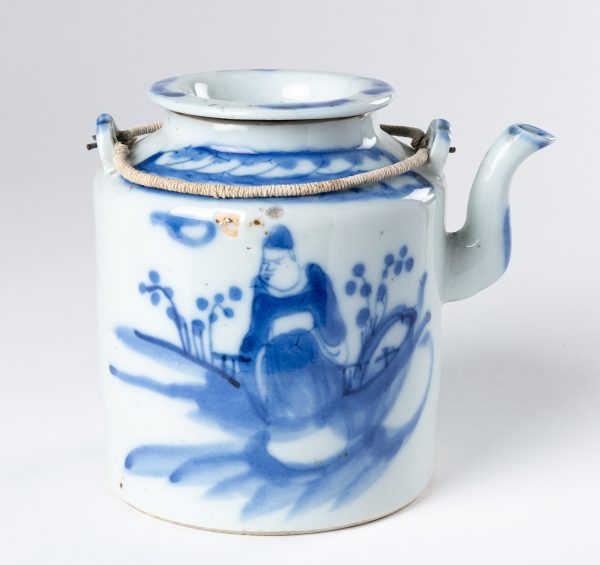Covered Teapot with a hand painted image of a fat monk in a landscape. The cover is flat, the two handles are string wrapped metal.