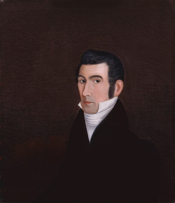 A formal portrait of a man wearing a dark coat with a high white collar.