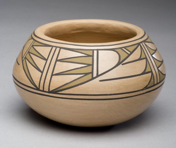 A cream colored clay background with brown and sage green colored decoration of abstract lines and shapes.
