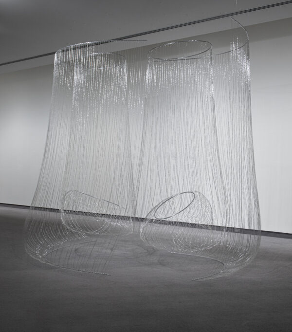 Gallery installation of a sculpture consisting of then beaded wire suspended from the ceiling form roundedceiling-to-floor pendulums
