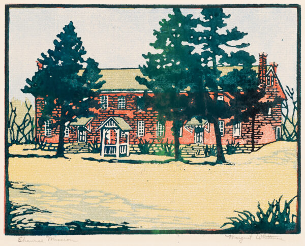 A brick building with three trees in front.