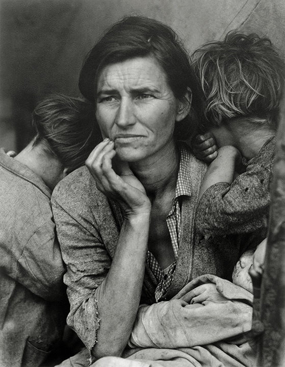 Black and white photograhy of a woman with her hand on her chin and two young children at each side, facing away,
