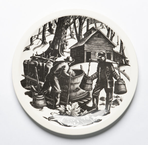 A decorative plate that has a wood engraving by Clare Leighton on it showing the process to make sugar from maple trees. Two men work pouring sap into a large wooden vat. Two ox are at the left, trees with buckets collecting sap and a small cabin are in the background