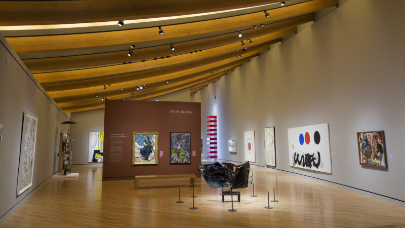 Interior of Crystal Bridges Museum of American Art with a wood floor, wood ceiling and works of art on the walls