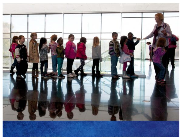 Cover of the 2021-2022 School Field Trip Guide with text across the top, Wichita Art Museum, School Field Trip Guide, 2021-2022 Academic Year. Photo in the middle of a group of childen in a line with one adult in front of a bank of windows. White text on a blue background at the bottom reads Free Tours for all school groups, Bus Reimbursement for school groups. Visit us online, wichitaartmuseum.org/learn