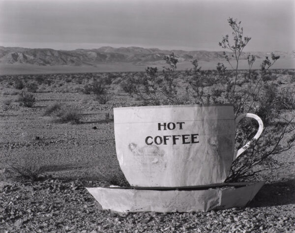 Black and white photograph of a large cup and sauce labeled 