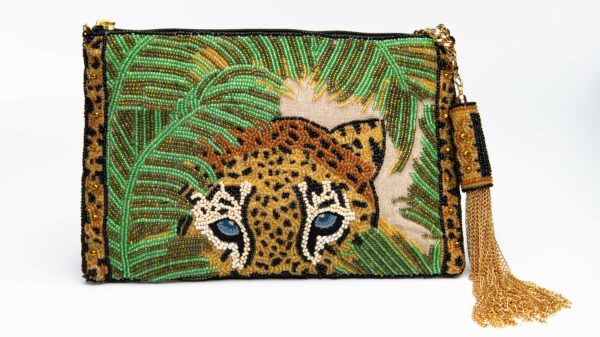 Beaded handbag with the image of a leopard's head surrounded by green ferns. Handbag has a gold tassel on the zipper.