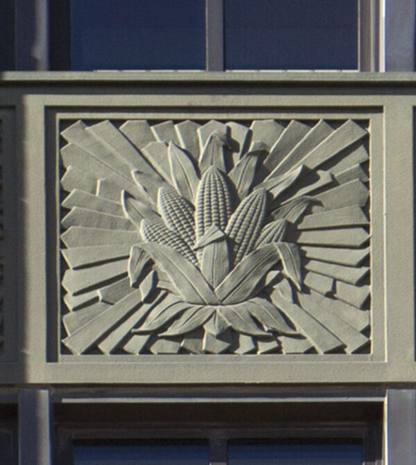 Relief sculpture in stone of ears of corn on a sunburst background