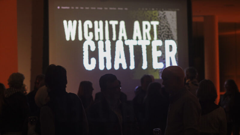 Photo of a dozen people in silhouette in front of a screen that reads Wichita Art Chatter in a sans-serif font