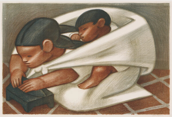 Hispanic woman kneeling on a brick floor kneading dough on a black surface, with a sleeping child on her back in a white sling
