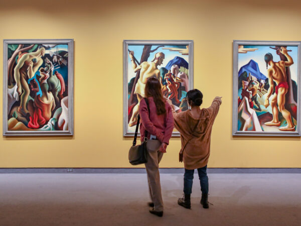 Back view of adult and child standing in a gallery in front of three paintings by Thomas Hart Benton