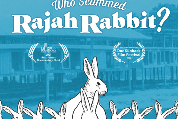 Aqua-tone photo that shAn aqua-tinted background of a photo of a line of rabbit hutches.. Text on the image reads Who Sammed Rajah Rabbit. Under that are two laural wreaths. On the left text reads Best Kansas Short Documentary, Tallgreass Film Festival, 2021. On the right text in the laurer reads Best Kansas Documentary, Doc Sunback Fi;m Festival, 2022. In the center is a large white rabbit, with smaller rabbits on either side