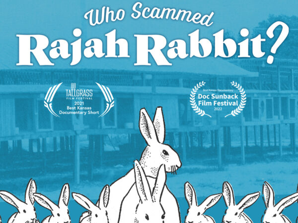 Aqua-tone photo that shAn aqua-tinted background of a photo of a line of rabbit hutches.. Text on the image reads Who Sammed Rajah Rabbit. Under that are two laural wreaths. On the left text reads Best Kansas Short Documentary, Tallgreass Film Festival, 2021. On the right text in the laurer reads Best Kansas Documentary, Doc Sunback Fi;m Festival, 2022. In the center is a large white rabbit, with smaller rabbits on either side