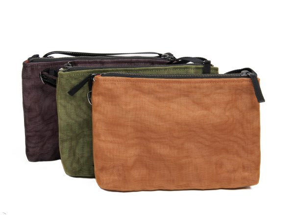 three clutch handbags, rectangle shaped with top zippers in tan, green and black.
